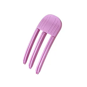 Close-up detail view of the pink plastic hair root volumizing clip, showing its anti-slip texture.