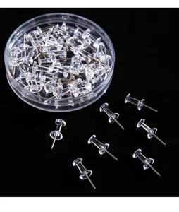 Transparent plastic pushpins detail shot showing clear thumb tacks and round storage box.