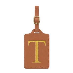 Étiquette de bagage en cuir PU marron avec lettre T brodée dorée et une boucle métallique solide.