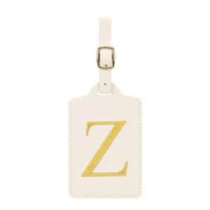 Gros plan d'une étiquette de bagage beige avec un élégant détail de lettre Z brodée.