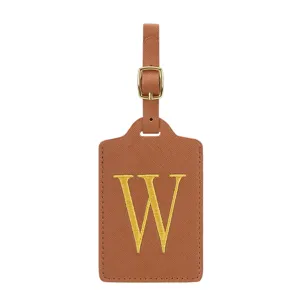 Vue de détail de l'étiquette de bagage en cuir PU marron avec boucle métallique et lettre W.
