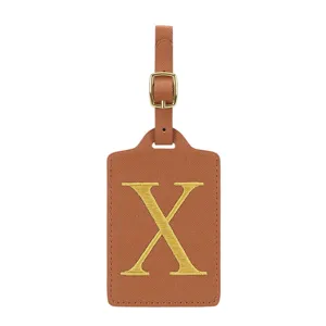 Étiquette de bagage en cuir PU marron avec lettre X brodée dorée et boucle métal.