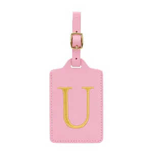 Primo piano dettagliato dell'etichetta bagaglio in pelle PU rosa con ricamo dorato e fibbia.