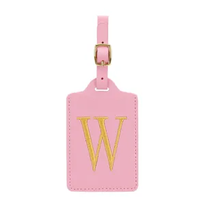 Primo piano dettagliato di etichetta valigia in pelle PU rosa con lettera dorata ricamata.