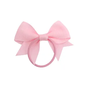 Vista dettagliata di un grazioso fiocco per capelli rosa in grosgrain per acconciature.