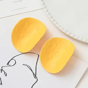 Gros plan détaillé des pinces à cheveux chips en PVC de simulation jaune, épingle snack.