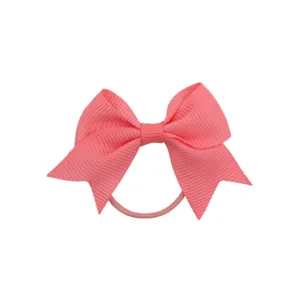 Primo piano dettagliato di un grazioso elastico per capelli con fiocco rosa per bambini.