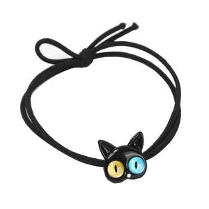 Gros plan détaillé de l'élastique pour cheveux chat noir mignon avec des yeux colorés et bande.