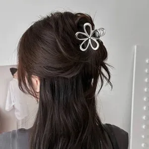 Vue détaillée d'une pince à cheveux fleur creuse en métal argenté pour coiffures élégantes.