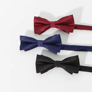 Close-up detail of classic men's bowties in wine red, dark blue, and black colors.