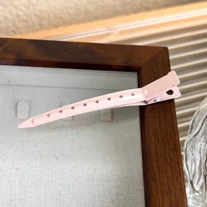Pink metal duckbill hair clip for root volume and styling, minimalist everyday hair accessory.