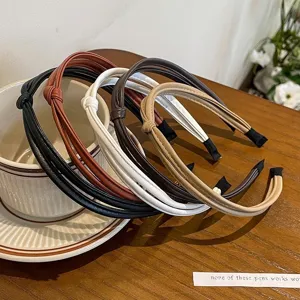 Detailed shot of minimalist PU leather braided hair hoops in multiple chic neutral colors.