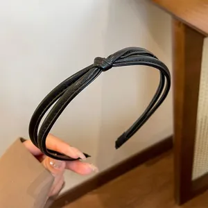 Black PU leather knotted headband for women, stylish minimalist hair hoop, French chic accessory.