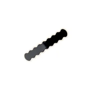 Detailed view of the black wavy hair clip with white edge, showcasing its sleek design.