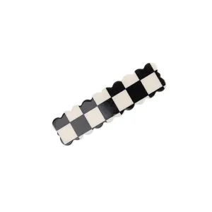 Black and white checkerboard hair clip detail showing the unique scalloped edge design.