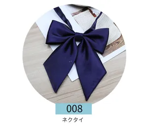 Detailed close-up of a classic navy blue JK uniform bow tie with smooth satin fabric texture.