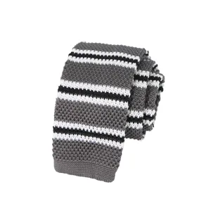 Detail view of a stylish grey knit necktie featuring classic white and black horizontal stripes.