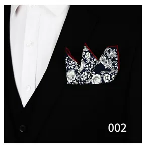 Vista detallada de pañuelo de bolsillo floral azul marino con borde rojo en traje.