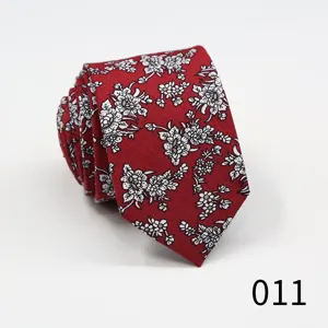 Close-up detail of a red men's necktie featuring an elegant white floral jacquard pattern.