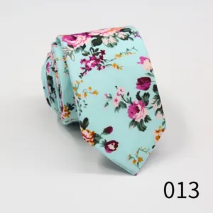 Close-up detail of light blue floral cotton necktie, stylish narrow arrow design for men.