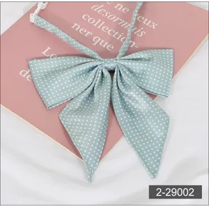 Detailed close-up of light green polka dot JK uniform bow tie featuring an adjustable strap.