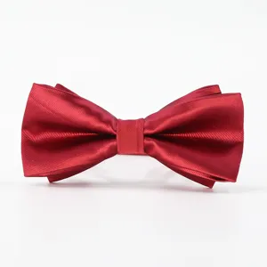 Close-up detail of a classic red silk bow tie, perfect for weddings and formal business suits.