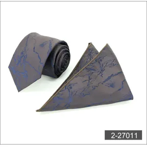Men's business necktie and pocket square set with blue abstract pattern on brown fabric.