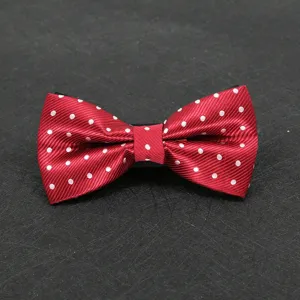 Close up detail of classic red bow tie featuring elegant white polka dots for men's formal suit wear.