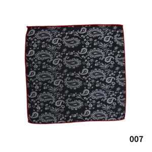 Detalle de pañuelo de bolsillo paisley en blanco y negro con borde rojo llamativo.
