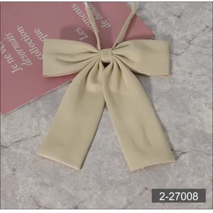 Detail shot of beige JK uniform bow tie, featuring smooth texture and elegant flat corner design.