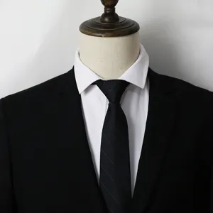 Gros plan détaillé d'une cravate noire classique à rayures portée avec un costume formel.
