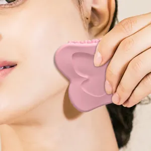Silicone facial gua sha scraping board, thick pink massage tool for face and neck skin care.