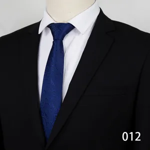 Detailed view of classic blue paisley necktie paired with black suit and white shirt.