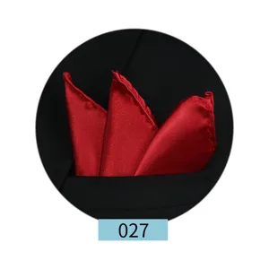 Pañuelo de bolsillo de satén rojo en detalle, doblado de forma ordenada en un bolsillo de traje.