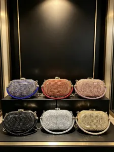 Detailansicht von luxuriösen Strass-Clutch-Taschen in leuchtenden Farben mit Metallketten.