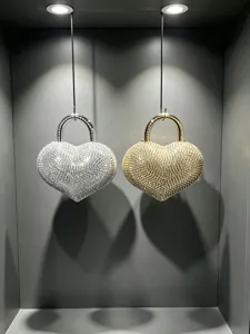 Primo piano della borsa da sera a forma di cuore con strass, manico in metallo e finitura.