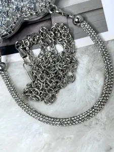 Exquisites Strass-Herz-Handtaschendetail mit funkelnden Kristallen und glänzenden Ketten.