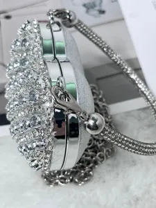 Detaillierte Nahaufnahme einer Strass-Herz-Clutch, funkelnde Abendtasche mit Kette.