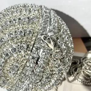 Detailed view of the sparkling crystal rhinestone spherical evening minaudiere clutch bag.