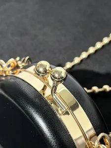 Gedetailleerd overzicht van zwarte PU mini tas met gouden metalen sluiting en ketting.