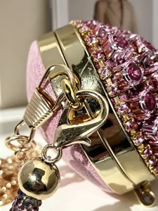 Detailansicht der Luxus rosa Strass Mini Abendtasche mit goldener Hardware und Herzverschluss.