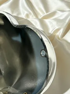 Primo piano dettagliato della borsa da sera argentata a forma di cuore con bordo e chiusura.