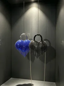Vue détaillée de sacs de soirée en forme de cœur en strass avec franges et poignée.