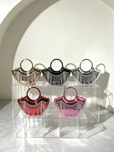 Nahaufnahme Detail glänzende Abendtasche mit funkelnden Strass-Quasten und rundem Griff.