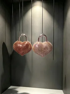 Dettaglio borsa da sera a cuore con strass, elegante minaudière di cristallo con manico in metallo.