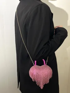 Détail de sac de soirée à franges strass cœur rose avec des cristaux étincelants.