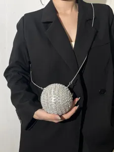 Detail of sparkling rhinestone sphere evening bag with silver chain strap for party outfit.