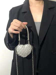 Detaillierte Nahaufnahme der glitzernden Strass-Herz-Handtasche mit silberner Kette.