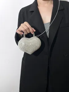 Dettaglio borsa da sera a cuore in strass scintillanti con elegante tracolla a catena d'argento.