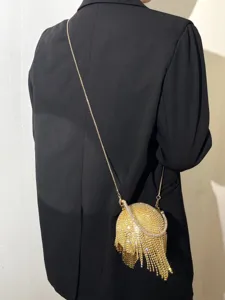 Vue détaillée de l'élégant sac de soirée sphérique en strass doré avec franges et chaîne.